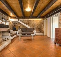 A fireplace room in a villa with a wooden decor floor and stone walls.