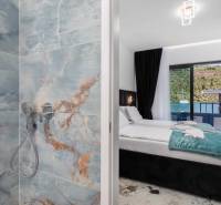 Bathroom with marble tiles and a bedroom in a villa with a sea view.