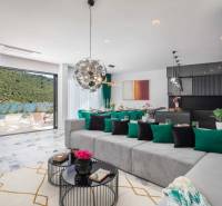 A spacious living room of the villa with a view of the pool and natural surroundings.