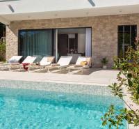 The exterior of the villa in Bale with a pool and loungers on the terrace.