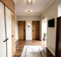 A hallway in a 3-room apartment with a wooden decor floor and light-colored walls.