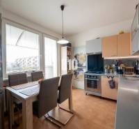 Kitchen in a 4-room apartment with a dining table, brown chairs, and a large window.
