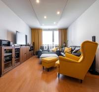 Living room in a 4-room apartment with a wood-patterned floor and yellow armchairs.