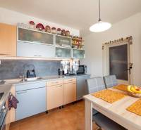 A kitchen in a 4-room apartment with a computer and a kitchen unit in wooden decor.
