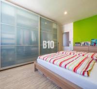 A bedroom in a 4-room apartment with a wooden decor floor and a spacious wardrobe.