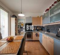 A kitchen in a 4-room apartment with a dining table and built-in appliances.
