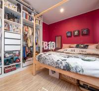 Bedroom with a bed, wood-patterned floor, and open wardrobe in a 4-room apartment.