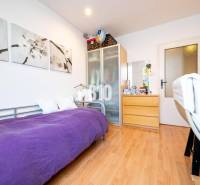 A room in a 4-room apartment with a single bed, a wardrobe, and a floor with a wooden decor.