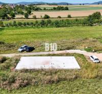 Plots - housing in Čeľadice with houses, cars, and natural landscape in the background.