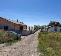 Family houses near a road surrounded by grass in Čeľadice, residential plots.