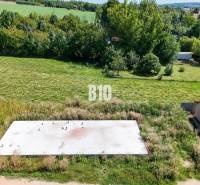 Building plot in Čeľadice, green landscape with a concrete foundation and a car.