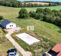 A plot of land for living in Čeľadice includes a house, greenery, and cars.