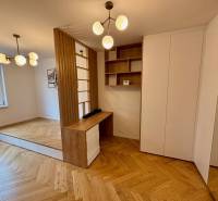 Interior of a 2-room apartment with a wooden decor floor and minimalist lighting fixtures.