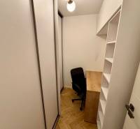 A small study in a 2-room apartment with a wooden decor floor and built-in wardrobes.