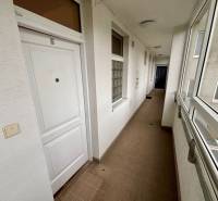 Hallway in a 2-room apartment with white doors and tiles.