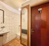 Bathroom in a family house with a sink, shower, and a door labeled 