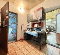 Interior of commercial premises with tiles, a workbench, and tools on shelves.