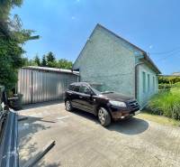 A family house on Záblatská Street in Trenčín with a car and a metal garage.