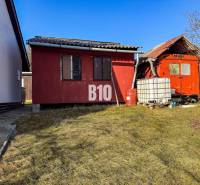 Red garden cottages in the Gardens in Nitra with a plastic water tank.