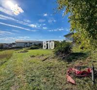 Land for residential use in Nitra, grassy area with greenery and sunny sky.