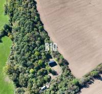 An aerial view of a cottage in Lackov surrounded by fields and forest.