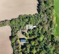 Aerial view of a cottage in Lackov surrounded by fields and forest.
