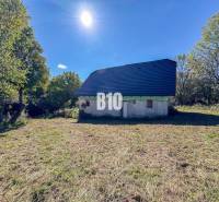 A cottage in Lackov surrounded by nature, with a blue roof, sunny day.