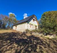 A cottage in Lackov surrounded by nature under a blue sky.