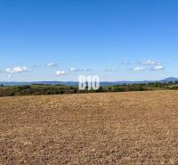 A view of a cultivated field in Lackov, with a view of the hills and a clear sky.