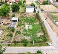 Plots - housing in Bardoňovo with grass, surrounded by houses and gardens, rural character.