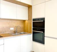 Kitchen unit with storage cabinets in a 2-room apartment, floor with wood decor.