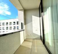 The balcony of a 2-room apartment on Karpatská Street in Poprad with a view of a lower building.
