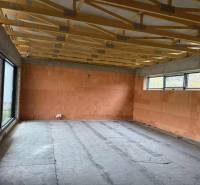 Interior of a family house with a large window and ceiling beams, empty room.