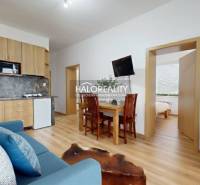 Living room of a 3-room apartment with a wood-patterned floor and comfortable seating.