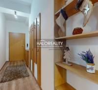A hallway in a 3-room apartment with decorative shelves and a floor with a wooden decor.