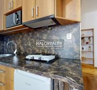 Living room with a kitchenette in a 3-room apartment with a wooden decor floor.
