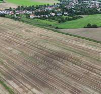 Agricultural and forest land in Nová Ves nad Váhom surrounded by village buildings and greenery.