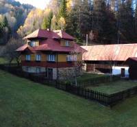 A family house in Zázrivá surrounded by forests, with stone and wooden construction.