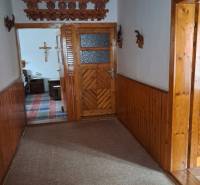 A hallway in a family house with wooden paneling and decorative elements on the wall.