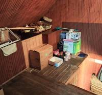 The attic of a family house with storage space, boxes, and a floor with a wooden decor.