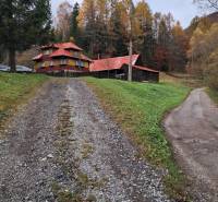 An autumn family house with a sloped roof in Zázrivá, surrounded by forests.