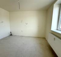 A room in a 2-room apartment with walls ready for painting and a radiator by the window.