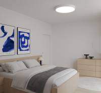 A bright bedroom in a two-room apartment with wooden floor decor and paintings on the wall.