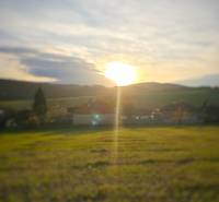 Sunset over family houses in Dobrá Voda, surrounded by natural scenery.