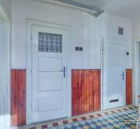 The interior of a family house with a tiled floor and wooden wall paneling.