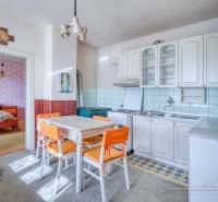 A kitchen in a family house with a dining table and a view into the bedroom.