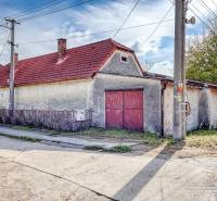 A family house on Dobrá Voda Street in the town of Dobrá Voda with a red roof and a fence.
