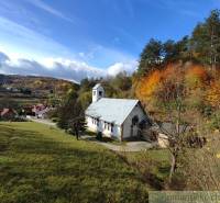 A church surrounded by nature and colorful trees on the outskirts of Hlboké nad Váhom in the gardens.