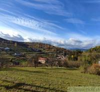 Landscape in Hlboké nad Váhom, gardens with hills and autumn nature under a blue sky.