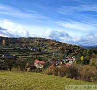 A view of picturesque gardens in Hlboké nad Váhom with a hilly landscape in the background.